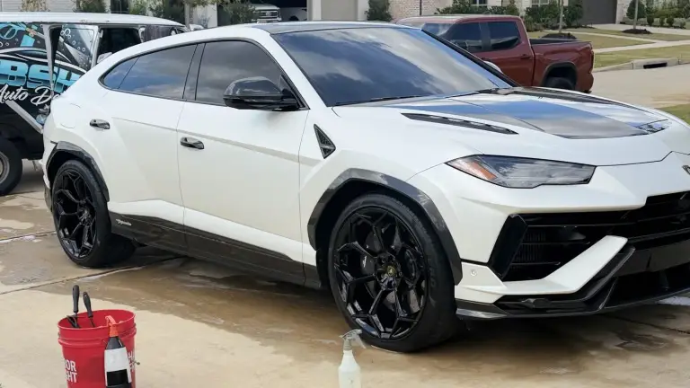 White Lamborghini Urus on a wet driveway